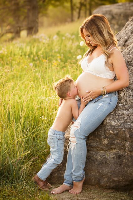 perryville maternity photographer, Cape Girardeau maternity photographer, child kissing belly, mother and son, sunset, golden sun, little boy with mom, belly bump