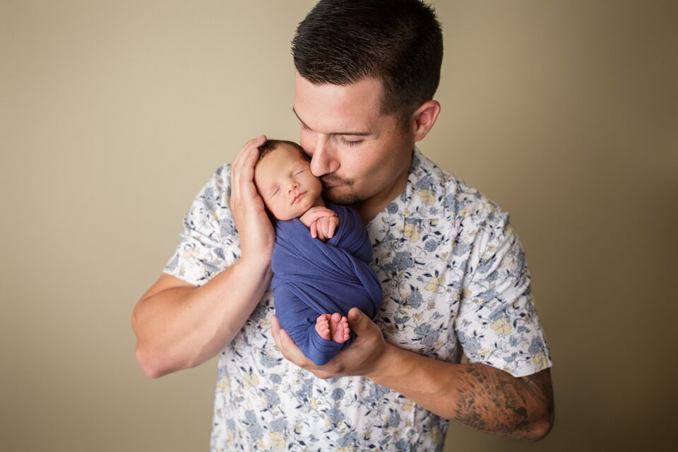 Perryville newborn photographer, Cape Girardeau newborn photographer, dad holding baby, dad kissing baby, studio, newborn photos