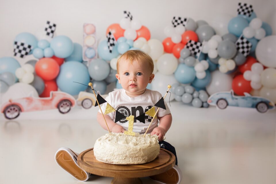 perryville cake smash photographer, Cape Girardeau cake smash photographer, race car balloon first birthday, intuition backgrounds, red head baby, cake, race car