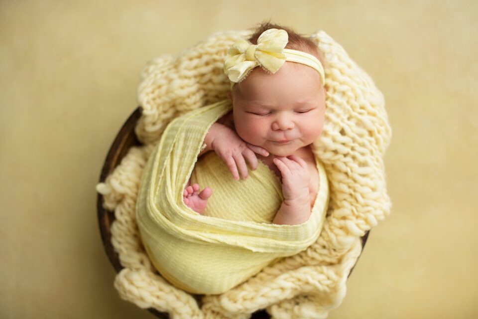 Perryville newborn photographer, Cape Girardeau newborn photographer, newborn baby photoshoot, yellow backdrop, yellow setup, baby girl, yellow bow