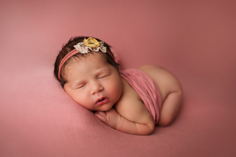 perryville newborn photographer, Cape Girardeau newborn photographer, Missouri Newborn photographer, lots of hair, baby photoshoot, pink backdrop, yellow bow, baby sleeping, ste. Genevieve newborn photographer
