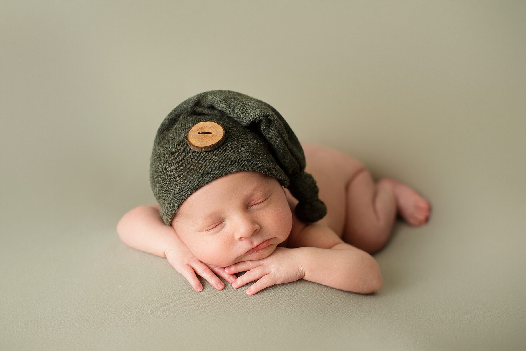 St. Louis newborn photographer, perryville Missouri newborn photographer, baby sleeping, green blanket, green hat, wood circle