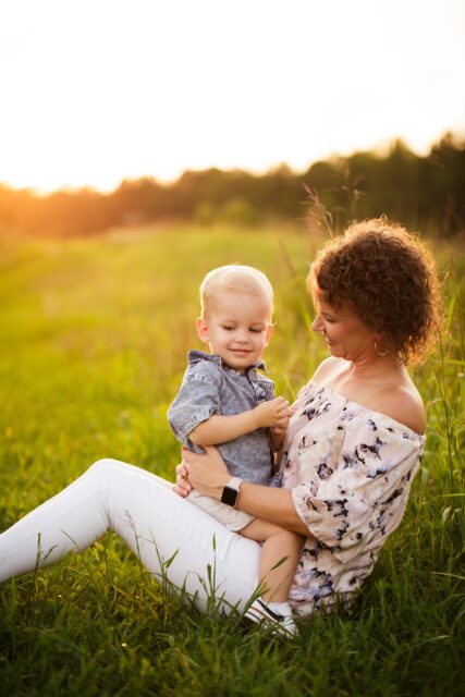 perryville photographer, Cape Girardeau photographer, Farmington newborn photographer, mom holding baby, sun shining, sunset, little boy, green grass