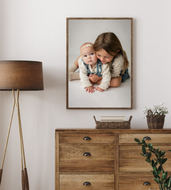 perryville newborn photographer, Jackson Missouri Newborn photographer, Cape Girardeau newborn photographer, wall art, baby looking at camera, sisters, wood dresser, white wall