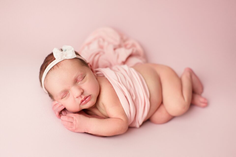 St. Louis newborn photographer, perryville Missouri Newborn photographer, farmington newborn photographer, pink backdrop, girl, baby laying on side