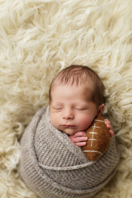 Farmington Missouri Newborn photographer, perryville Missouri Newborn photographer, fuzzy blanket, baby holding felt football, adorable baby