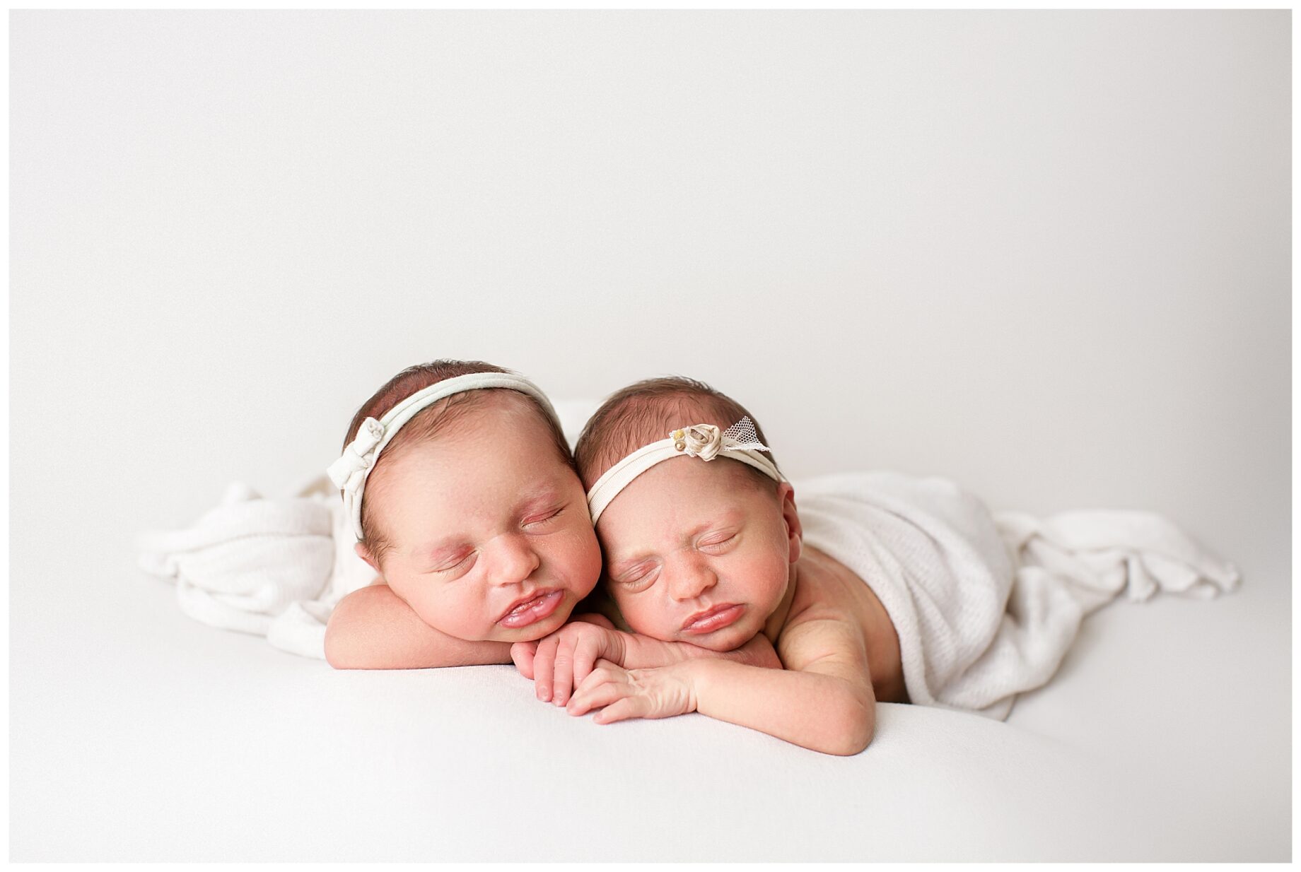 St. Louis newborn photographer, perryville Missouri Newborn photographer, farmington newborn photographer, twins, white backdrop, twins holding hands, baby girls
