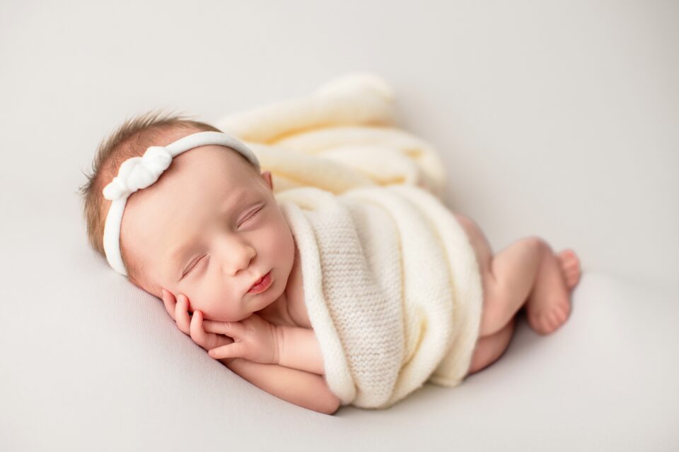 Cape Girardeau newborn photographer, perryville newborn photographer, baby on cream fuzzy rug, blonde baby, monochrome cream studio photos, newborn photo