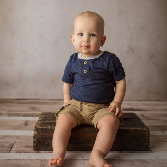 perryville newborn photographer, Cape Girardeau newborn photographer, baby boy sitting on bench, blue shirt, simple photoshoot, first birthday photoshoot, Missouri photographer