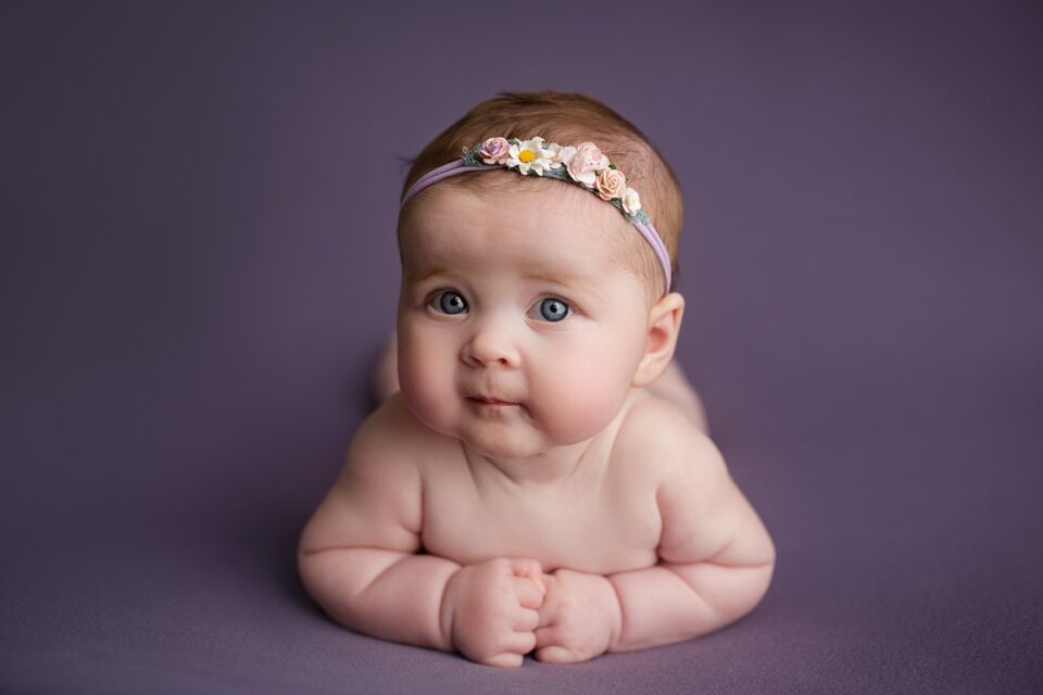 perryville newborn photographer, Cape Girardeau newborn photographer, purple blanket, tummy time, blue eyed baby, baby girl looking at camera