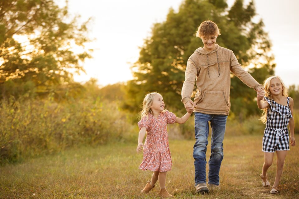 Cape Girardeau newborn photographer, perryville photographer, Farmington newborn photographer, winter photoshoot, dam, siblings, laughing, holding hands, gold sun