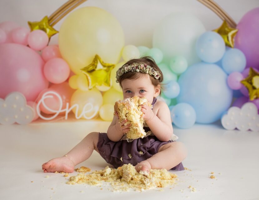 Cape Girardeau cake smash photographer, baby eating cake, rainbow balloon cake smash, photography by Kasey Duvall, Perryville photographer