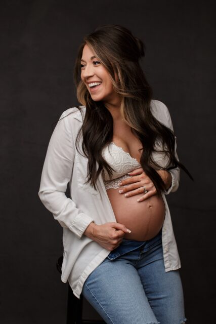perryville maternity photographer, Cape Girardeau maternity photographer, sexy motherhood photos, studio maternity session, brown backdrop, white shirt, white bralette, looking away from camera