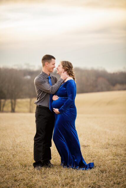 Cape Girardeau maternity photographer, perryville maternity photographer, sunset photos, gold sun, top of hill, blue velvet maternity gown, outside maternity photos