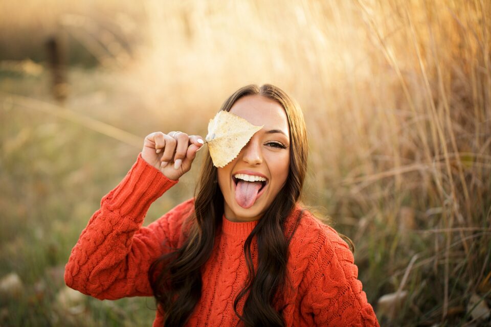 perryville senior photographer, Cape Girardeau senior photographer, Farmington senior photographer, sticking out tongue, orange shirt, tall brown grass