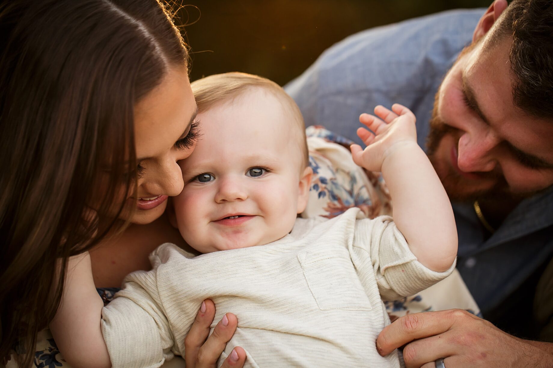 st Louis Missouri Newborn family photographer, Farmington Missouri Newborn family photographer, perryville Missouri Newborn family photographer, baby boy smiling at camera, white shirt, dad looking at baby, warm photoshoot